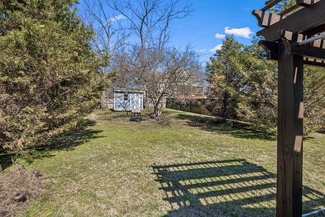 view of yard featuring an outbuilding, a storage shed, and fence