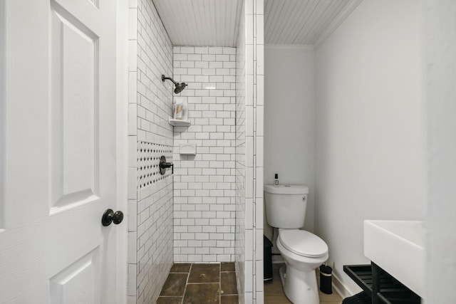 bathroom with toilet and a tile shower