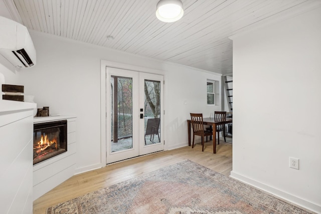 doorway to outside featuring wood finished floors, wood ceiling, french doors, a wall mounted air conditioner, and a glass covered fireplace