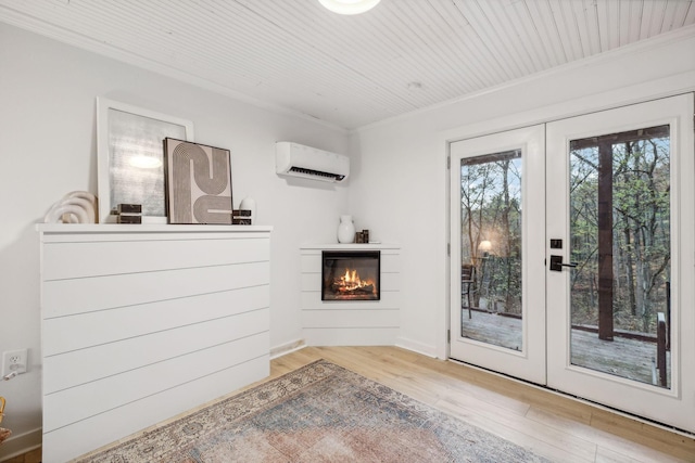 doorway featuring wood finished floors, an AC wall unit, french doors, a glass covered fireplace, and crown molding