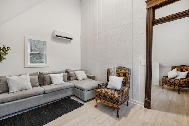 living room featuring light wood-type flooring, a wall mounted air conditioner, and high vaulted ceiling