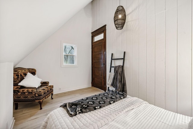 bedroom with light wood-type flooring and lofted ceiling