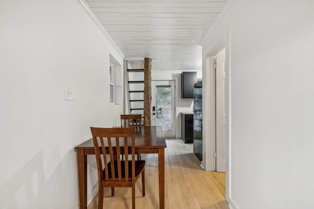 corridor featuring wood ceiling, ornamental molding, and light wood-style flooring