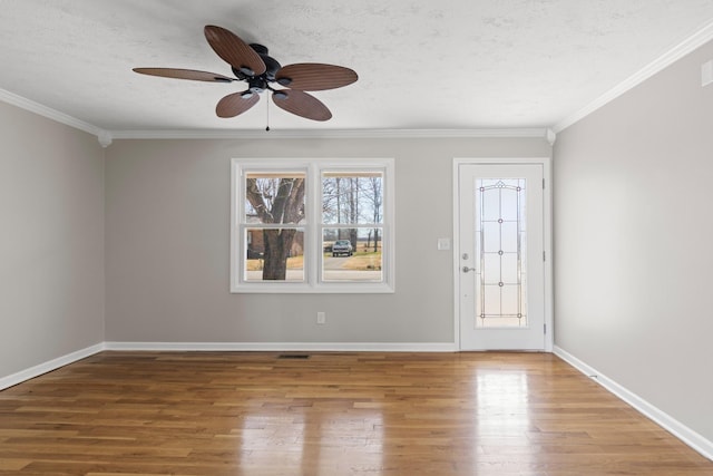 interior space with crown molding, a textured ceiling, and wood finished floors