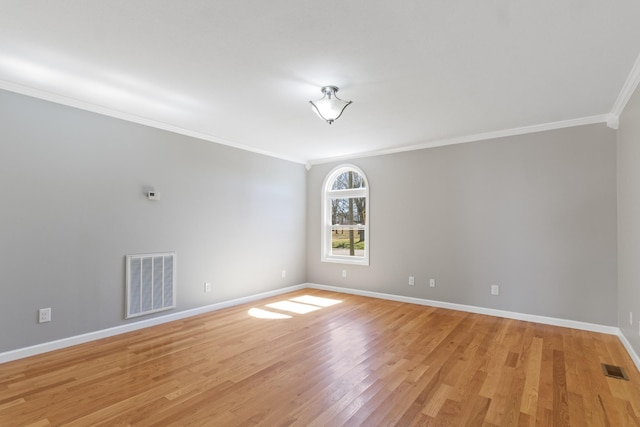 spare room featuring baseboards, crown molding, visible vents, and light wood-style floors