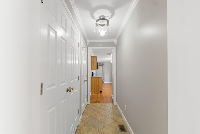 corridor with ornamental molding, visible vents, and baseboards