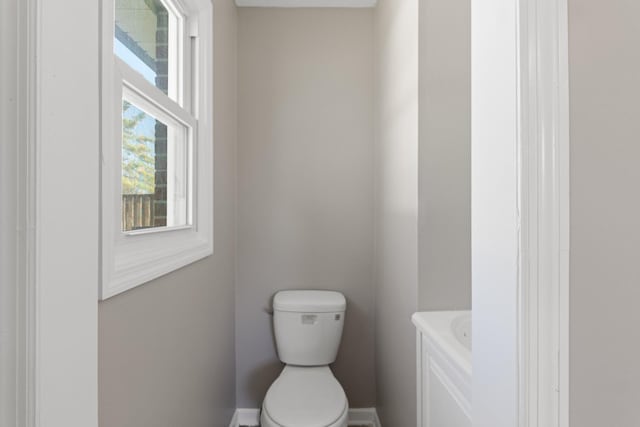 bathroom featuring baseboards, toilet, and a bathing tub