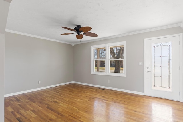 foyer entrance with light wood finished floors, baseboards, and ornamental molding