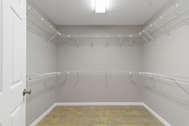 spacious closet with stone finish flooring