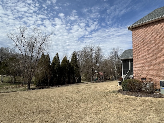 view of yard featuring a sunroom and a playground