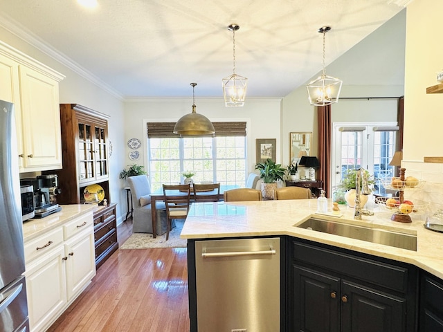 kitchen with wood finished floors, stainless steel appliances, white cabinets, crown molding, and dark cabinets