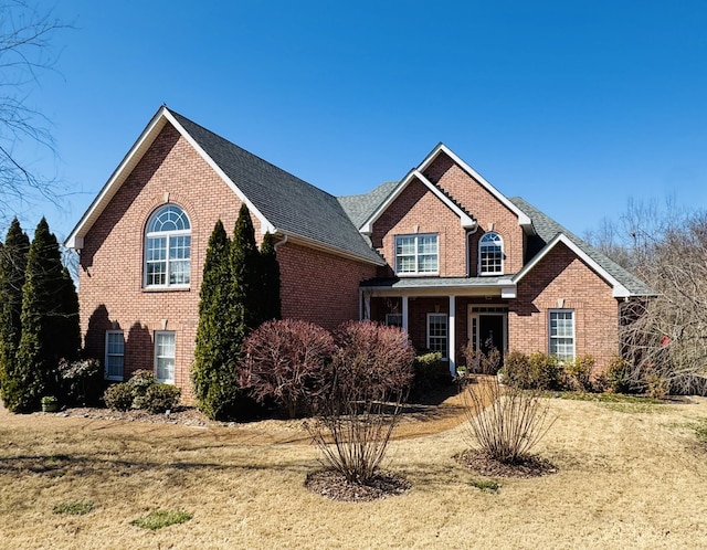 traditional-style home with brick siding and a front yard