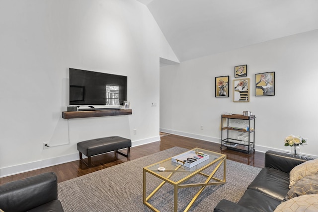 living area featuring lofted ceiling, baseboards, and wood finished floors