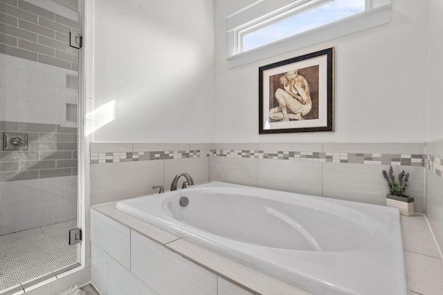 bathroom with a stall shower and a garden tub