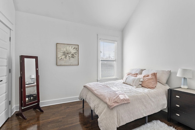 bedroom featuring dark wood-style floors, lofted ceiling, and baseboards