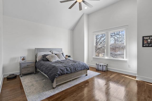 bedroom with hardwood / wood-style flooring, a ceiling fan, baseboards, and high vaulted ceiling