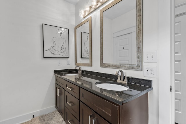 full bath featuring double vanity, a sink, and baseboards