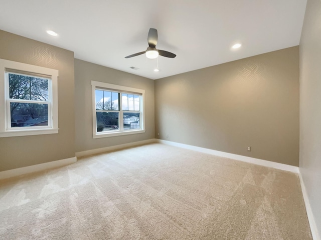 spare room with recessed lighting, light carpet, ceiling fan, and baseboards