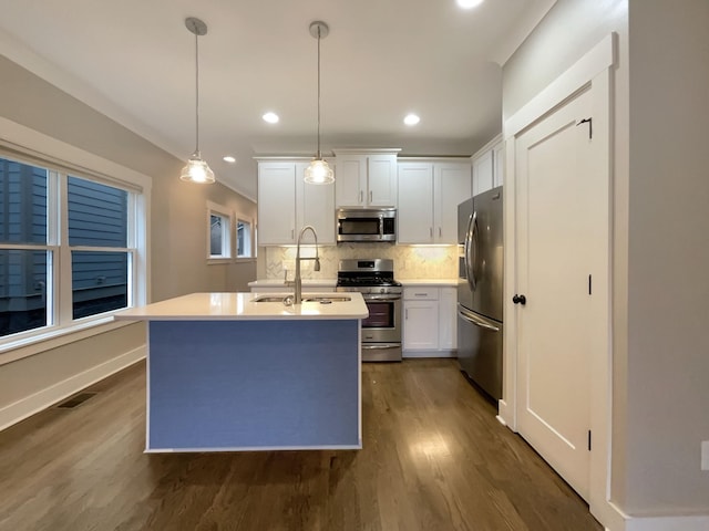 kitchen with visible vents, backsplash, dark wood-type flooring, stainless steel appliances, and a sink