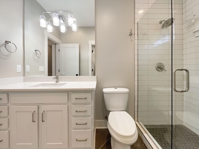 bathroom featuring toilet, a stall shower, baseboards, and vanity