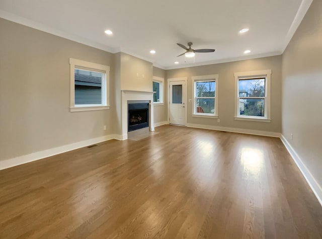 unfurnished living room featuring crown molding, recessed lighting, a fireplace with flush hearth, and baseboards