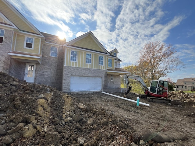 view of side of home with a garage and brick siding