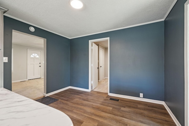 bedroom with crown molding, baseboards, and wood finished floors