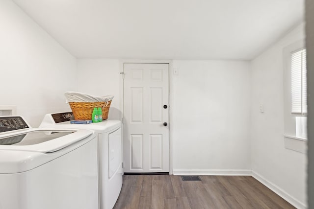 laundry room featuring washing machine and dryer, laundry area, wood finished floors, visible vents, and baseboards