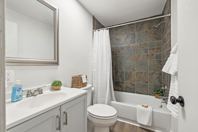 full bathroom with vanity, wood finished floors, shower / bath combo with shower curtain, and toilet