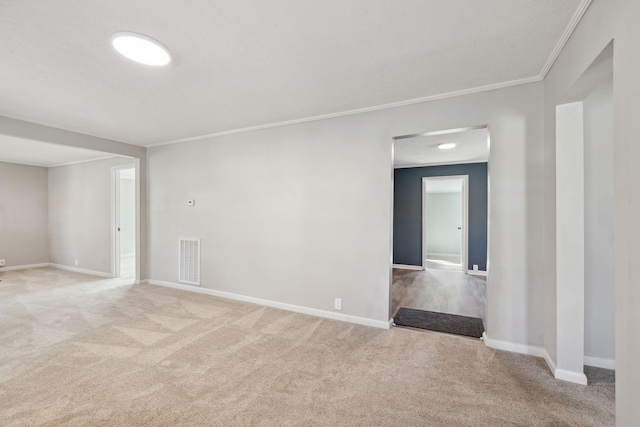 unfurnished room with baseboards, visible vents, crown molding, and carpet flooring