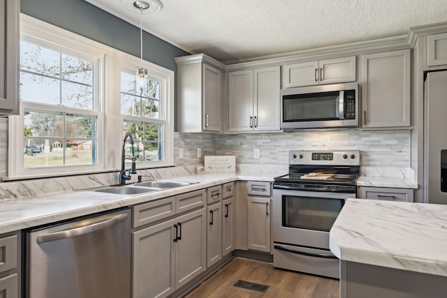 kitchen with gray cabinets, backsplash, appliances with stainless steel finishes, dark wood-type flooring, and a sink