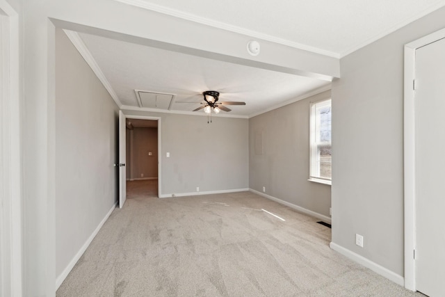 empty room with carpet floors, attic access, and ornamental molding