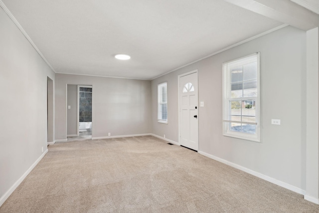 entrance foyer with light carpet, ornamental molding, and baseboards