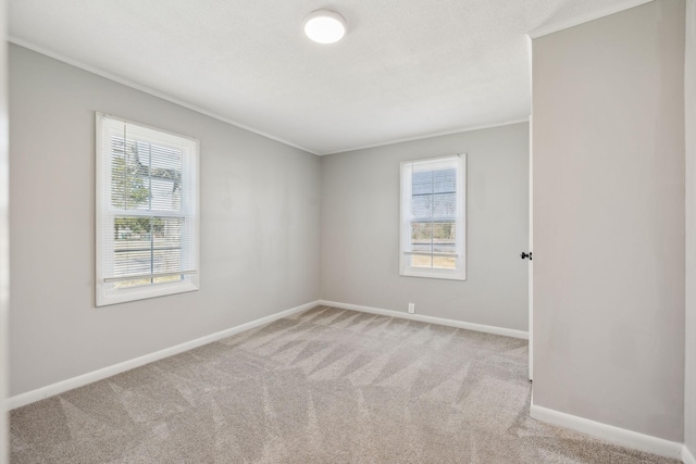 unfurnished room with baseboards, crown molding, and light colored carpet