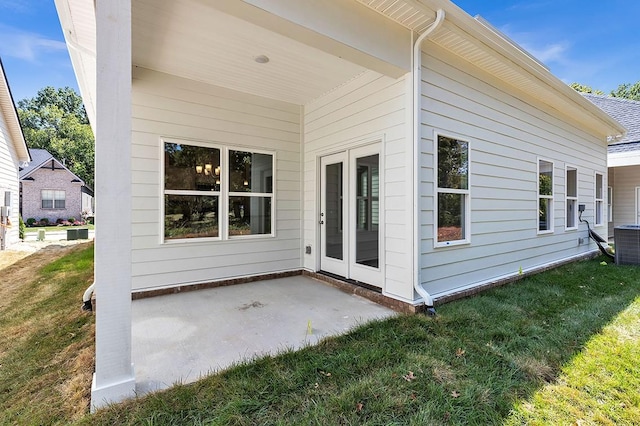 rear view of property with a patio area, cooling unit, and a lawn