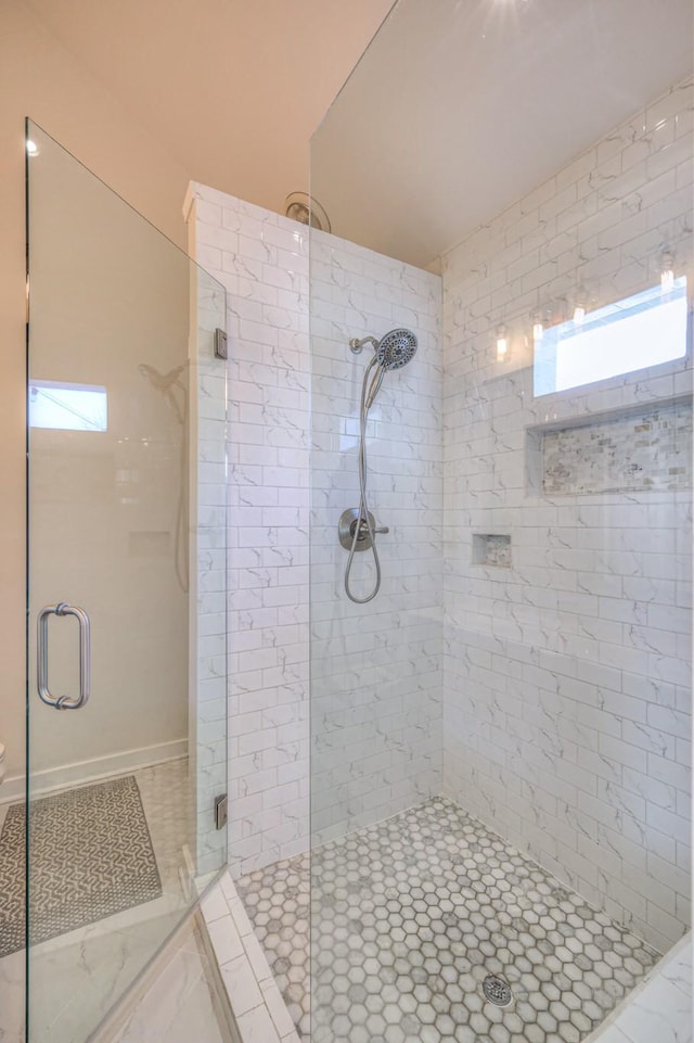 full bathroom featuring a stall shower and marble finish floor