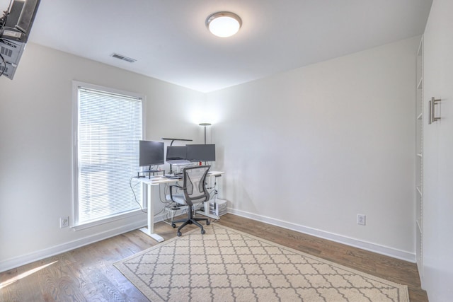 office with baseboards, visible vents, and wood finished floors