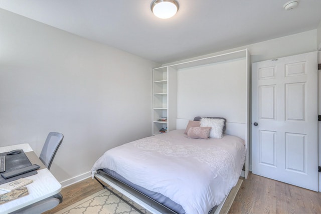 bedroom with baseboards and wood finished floors