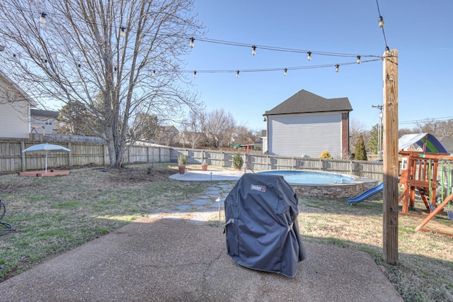 view of yard featuring a fenced in pool, a patio area, a fenced backyard, and a playground