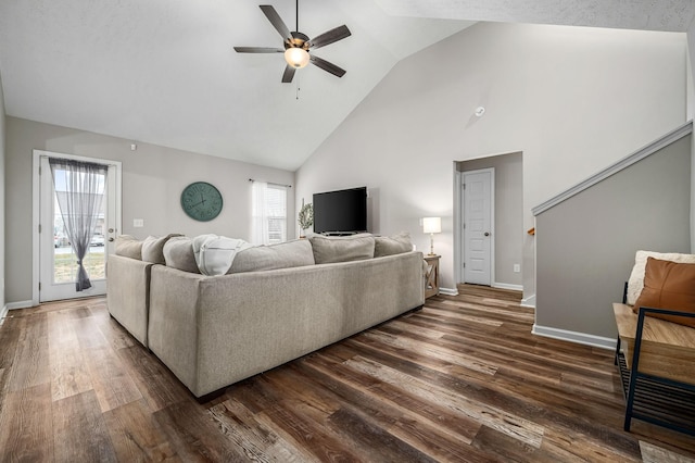 living area with high vaulted ceiling, dark wood-type flooring, a ceiling fan, and baseboards