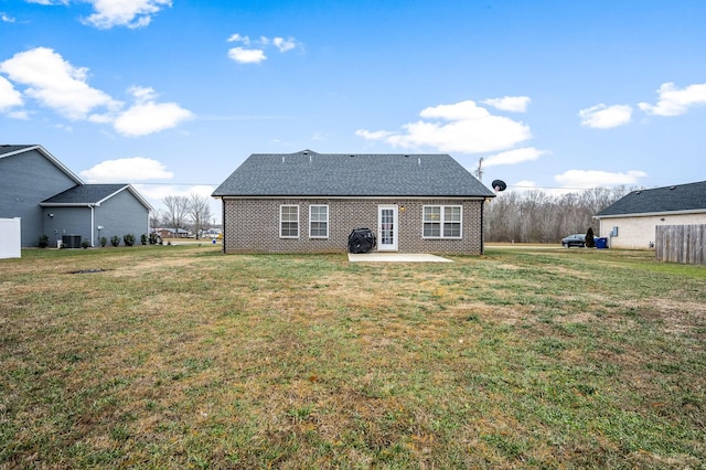 rear view of house featuring brick siding, a lawn, a patio area, and cooling unit