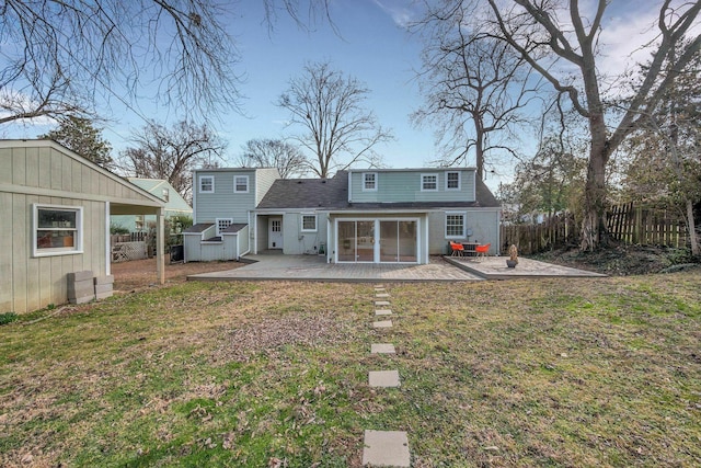 back of property featuring fence private yard, a yard, an outdoor structure, and a patio