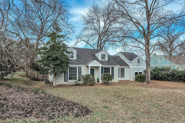 cape cod home featuring brick siding, a front yard, fence, and central air condition unit