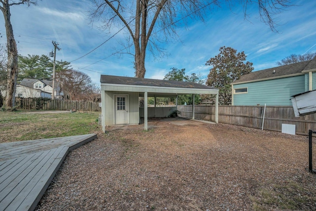 view of yard with fence private yard, a storage shed, a carport, and an outdoor structure