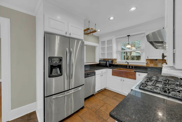 kitchen with stainless steel appliances, wall chimney exhaust hood, a sink, and white cabinets