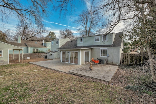 rear view of house featuring central AC unit, a fenced backyard, roof with shingles, a yard, and brick siding