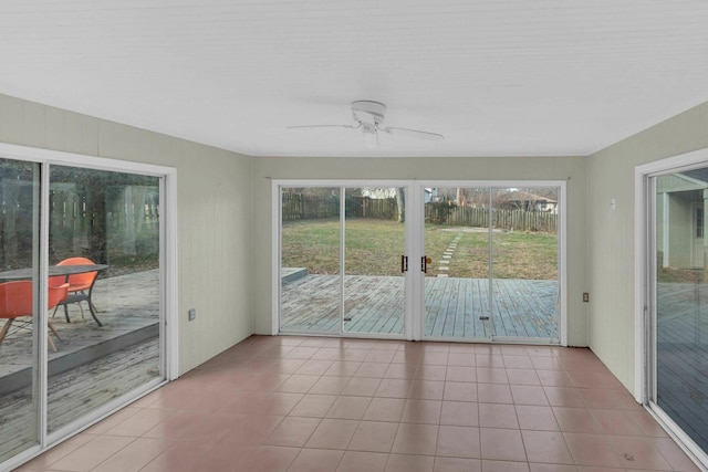 unfurnished sunroom featuring ceiling fan