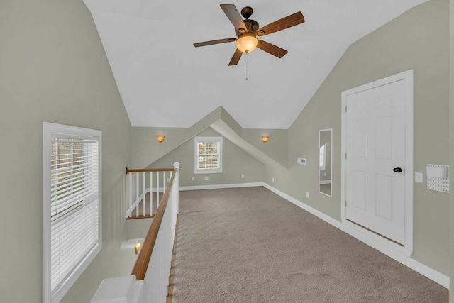 additional living space with carpet floors, ceiling fan, baseboards, and vaulted ceiling