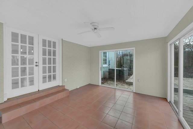 unfurnished sunroom with a ceiling fan and a wealth of natural light