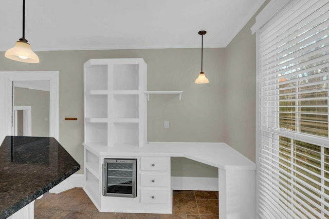 unfurnished office featuring beverage cooler and ornamental molding